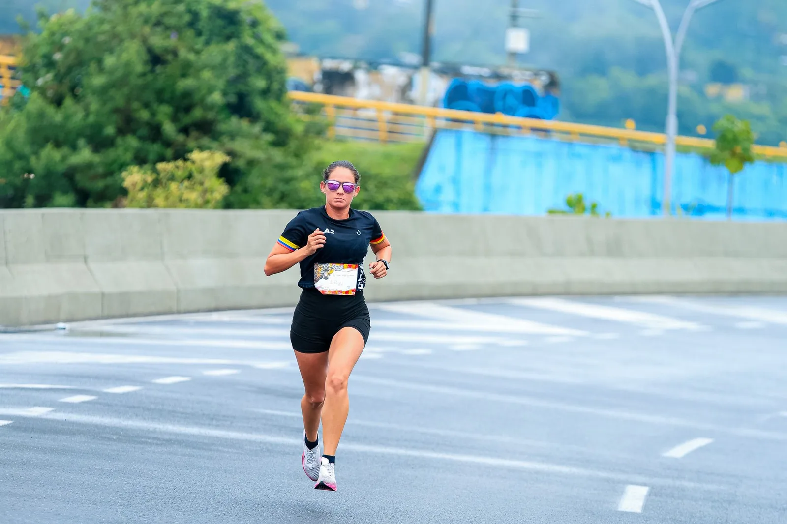Atleta correndo em uma prova de rua urbana sobre asfalto molhado