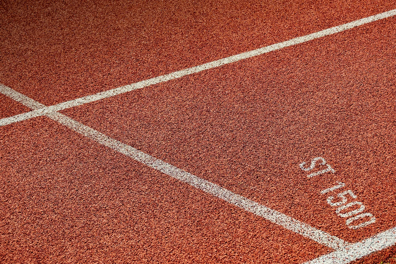 Marcações de distância e linhas brancas em uma pista de atletismo